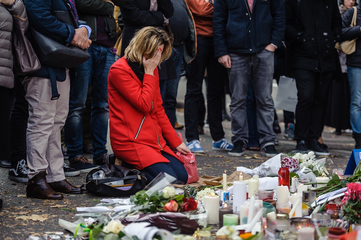 Οι άνθρωποι βάζουν λουλούδια και κεριά μπροστά από ένα αυτοσχέδιο μνημείο για τα θύματα των τρομοκρατικών επιθέσεων της 13ης Νοεμβρίου στη Γαλλία © EPA/CHRISTOPHE PETIT TESSON