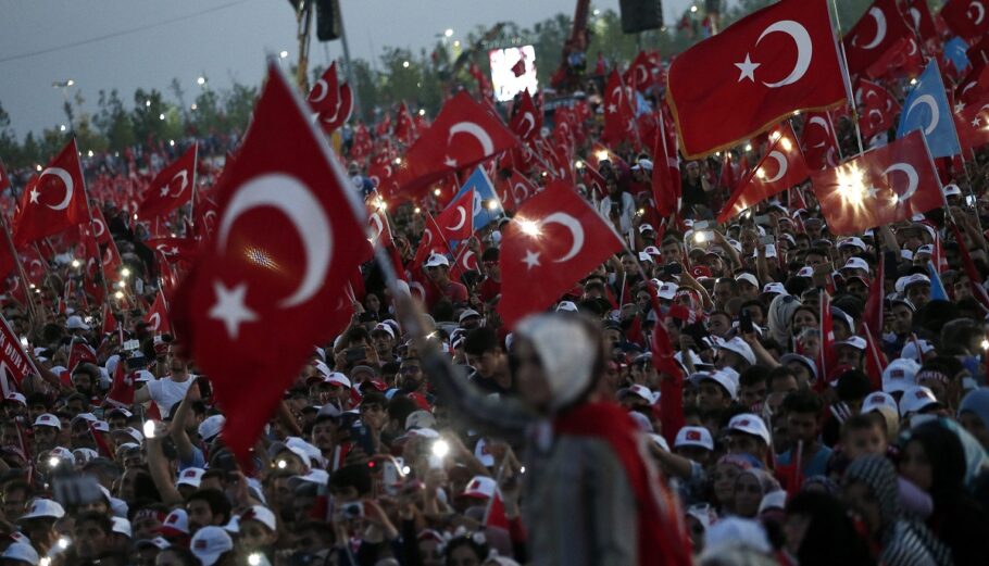 Άνθρωποι κρατούν τουρκικές σημαίες κατά τη διάρκεια συγκέντρωσης διαμαρτυρίας για την αποτυχημένη απόπειρα πραξικοπήματος στις 15 Ιουλίου 2016 © EPA/SEDAT SUNA
