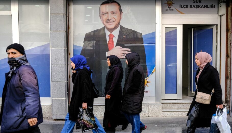 Άνθρωποι περπατούν μπροστά από αφίσα του Ερντογάν στην Τουρκία @ EPA/SEDAT SUNA