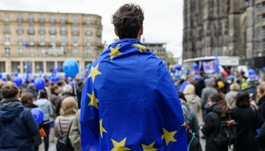 Διαδηλωτής στη Γερμανία με τη σημαία της ΕΕ στην πλάτη © EPA/JOERG SCHUELER