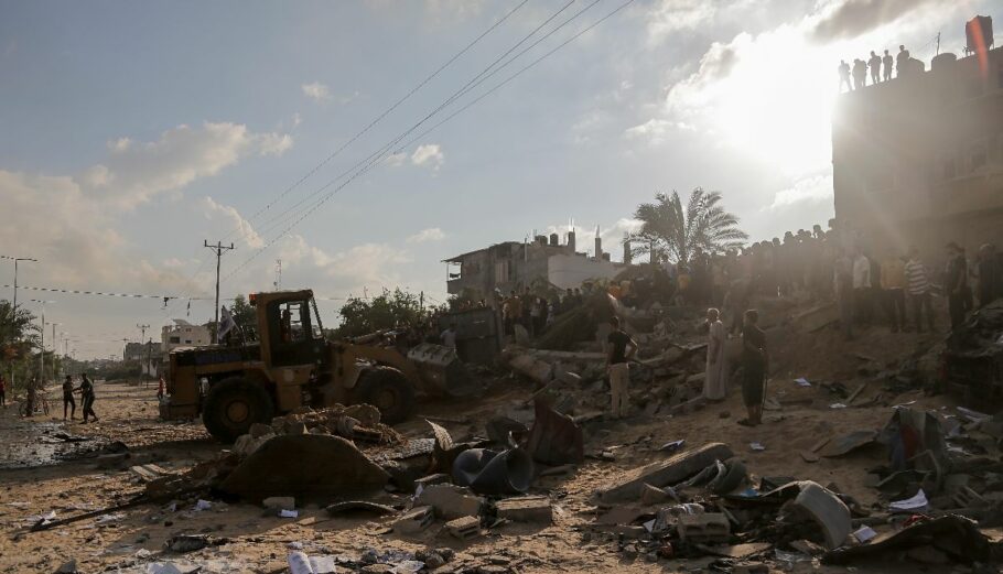 Παλαιστίνιοι ψάχνουν για επιζώντες στα συντρίμμια ενός κτιρίου κατοικιών που ισοπεδώνονται σε μια ισραηλινή αεροπορική επιδρομή© EPA/HAITHAM IMAD