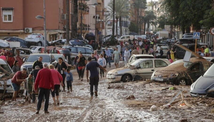 Κατοικοι περπατουν κατα μηκος ενός καλυμμένου από λασπη δρόμου στον πλημμυρόπληκτο δήμο Paiporta, στην επαρχια της Βαλενθια, Ισπανία@ EPA/MANUEL BRUQUE